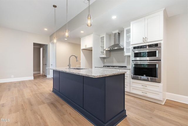 59 Cardinal Dr, Whispering Pines, NC 28327 - kitchen with a sink, wall chimney range hood, stainless steel appliances, light wood finished floors, and white cabinetry