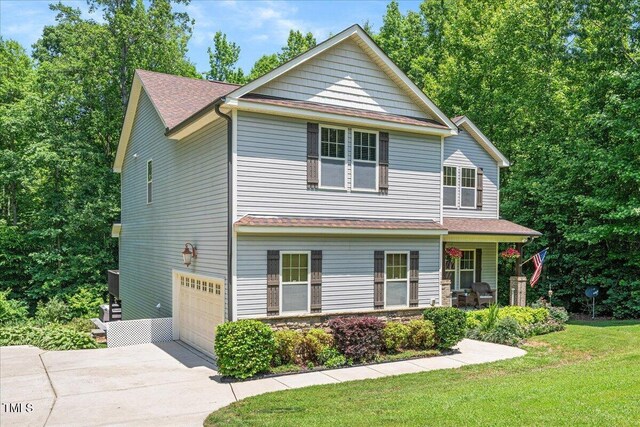 110 Lexington Ave, Zebulon, NC 27597 - view of front of home with driveway, a garage, covered porch, a front yard, and roof with shingles