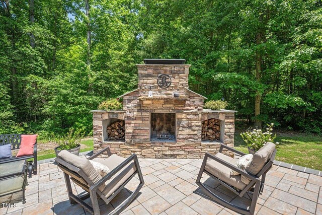 110 Lexington Ave, Zebulon, NC 27597 - view of patio featuring an outdoor living space with a fireplace and a view of trees