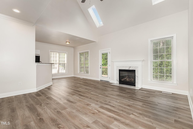 7936 Milltrace, Raleigh, NC 27615 - unfurnished living room with a skylight, a high end fireplace, baseboards, ceiling fan, and high vaulted ceiling