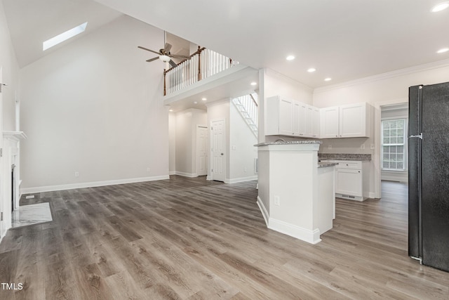 7936 Milltrace, Raleigh, NC 27615 - kitchen featuring freestanding refrigerator, a ceiling fan, open floor plan, white cabinetry, and ornamental molding