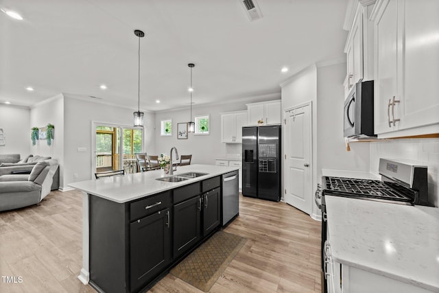159 Clear Water Rd, Louisburg, NC 27549 - kitchen featuring stainless steel appliances, a sink, open floor plan, white cabinetry, and light wood-type flooring