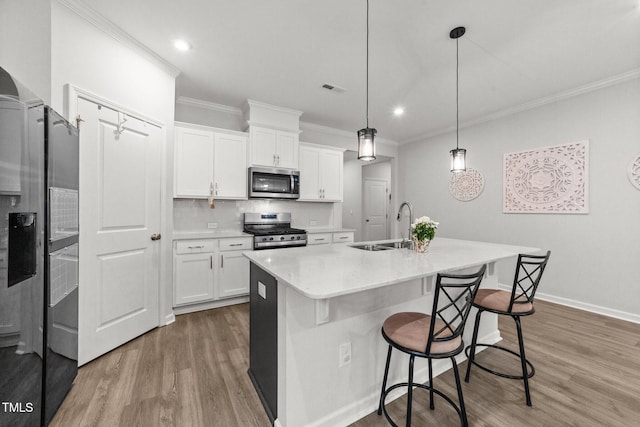 159 Clear Water Rd, Louisburg, NC 27549 - kitchen featuring stainless steel appliances, a sink, ornamental molding, wood finished floors, and white cabinets