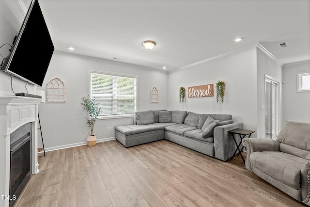 159 Clear Water Rd, Louisburg, NC 27549 - living room featuring crown molding, light wood finished floors, plenty of natural light, a glass covered fireplace, and recessed lighting
