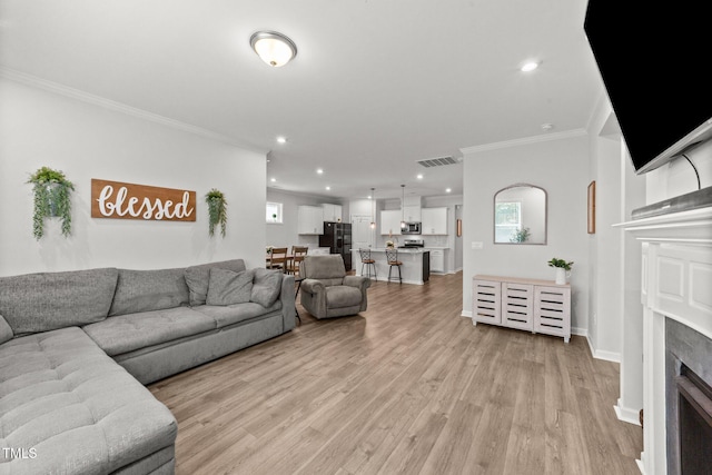 159 Clear Water Rd, Louisburg, NC 27549 - living room with ornamental molding, light wood-style flooring, a fireplace, recessed lighting, and baseboards