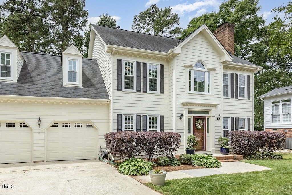 104 Odessa Cir, Cary, NC 27513 - colonial house with concrete driveway, an attached garage, a chimney, and roof with shingles