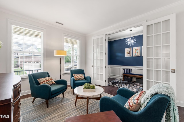 1577 Tice Hurst Ln, Apex, NC 27502 - living area featuring dark wood-style floors, ornamental molding, healthy amount of natural light, french doors, and a decorative wall