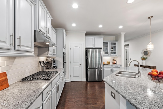 1577 Tice Hurst Ln, Apex, NC 27502 - kitchen with appliances with stainless steel finishes, under cabinet range hood, a sink, ornamental molding, and tasteful backsplash
