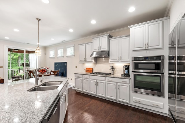 1577 Tice Hurst Ln, Apex, NC 27502 - kitchen with a sink, under cabinet range hood, stainless steel appliances, crown molding, and light stone countertops