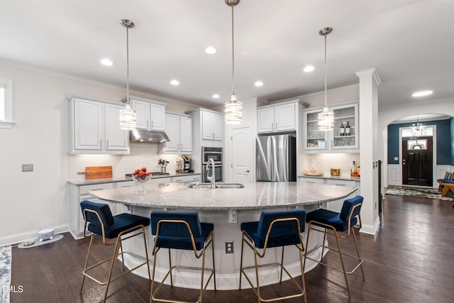1577 Tice Hurst Ln, Apex, NC 27502 - kitchen with appliances with stainless steel finishes, a large island, under cabinet range hood, backsplash, and ornamental molding