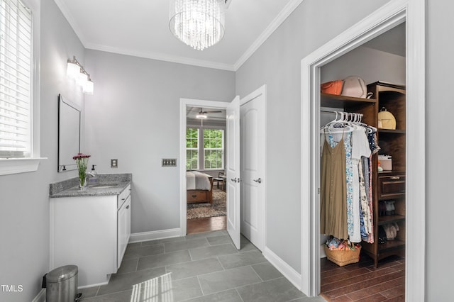1577 Tice Hurst Ln, Apex, NC 27502 - bathroom with vanity, ornamental molding, a chandelier, baseboards, and a spacious closet