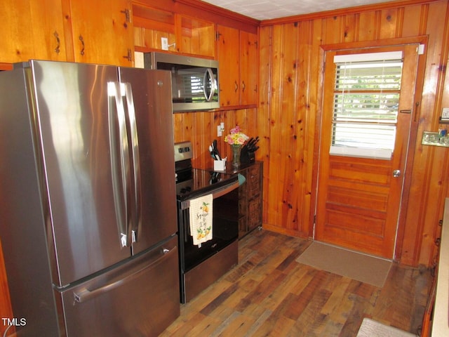1700 Warrenton Rd, Henderson, NC 27537 - kitchen featuring stainless steel appliances, wood finished floors, wooden walls, and brown cabinetry