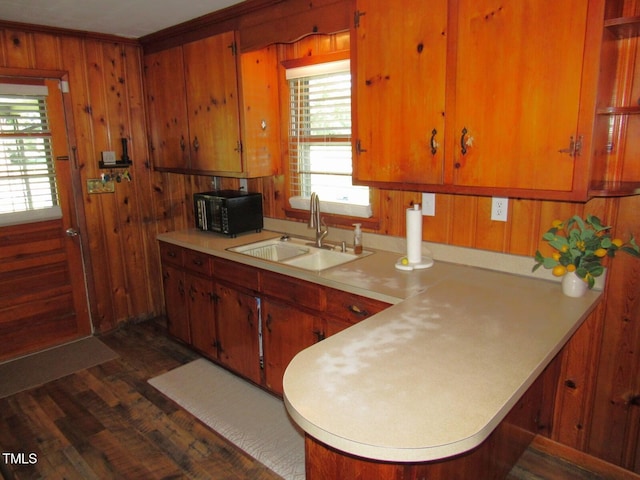 1700 Warrenton Rd, Henderson, NC 27537 - kitchen featuring a sink, light countertops, dark wood-style floors, wooden walls, and black microwave