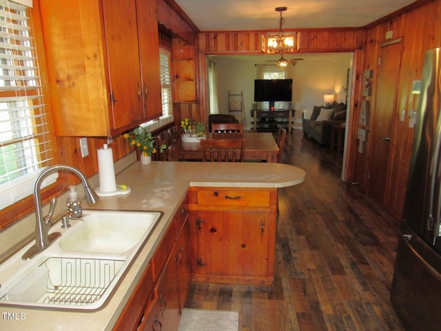 1700 Warrenton Rd, Henderson, NC 27537 - kitchen featuring a sink, a peninsula, freestanding refrigerator, wooden walls, and dark wood-style floors