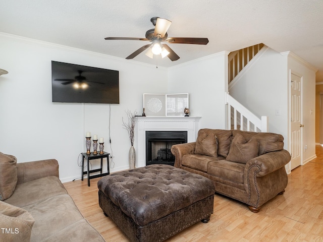 6304 Bermuda Way, Whitsett, NC 27377 - living area with a ceiling fan, stairs, crown molding, light wood finished floors, and a fireplace