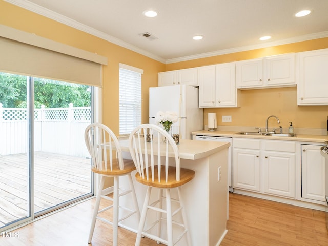6304 Bermuda Way, Whitsett, NC 27377 - kitchen with white appliances, white cabinetry, light wood-style floors, crown molding, and a kitchen breakfast bar