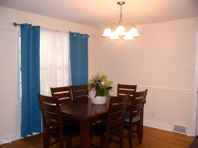 1809 S Garnett Ext, Henderson, NC 27536 - dining room featuring a chandelier, wood finished floors, and baseboards