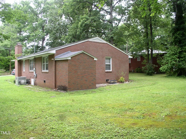 1809 S Garnett Ext, Henderson, NC 27536 - view of side of property featuring a chimney, brick siding, a yard, central AC unit, and view of scattered trees