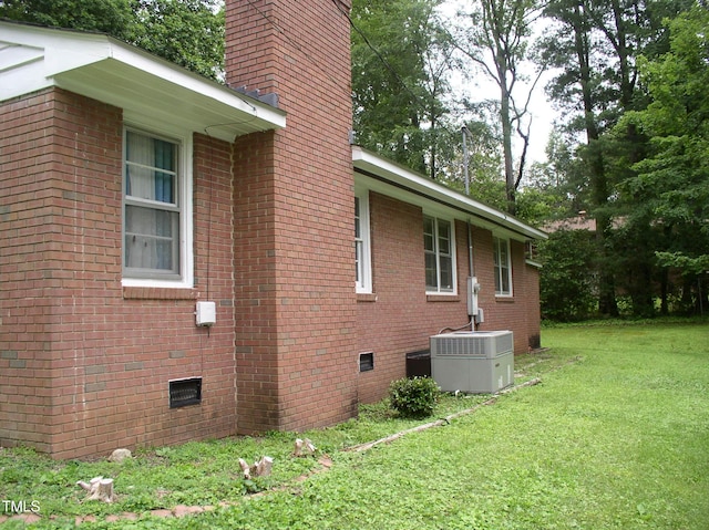 1809 S Garnett Ext, Henderson, NC 27536 - view of side of property with central air condition unit, a chimney, a lawn, crawl space, and brick siding