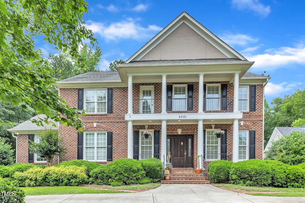 5521 Erinvale Ct, Holly Springs, NC 27540 - view of front of property featuring a balcony, brick siding, and covered porch