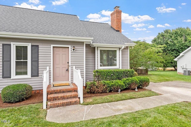 1228 Shakentown St, Knightdale, NC 27545 - entrance to property featuring a yard, a chimney, a shingled roof, and cooling unit