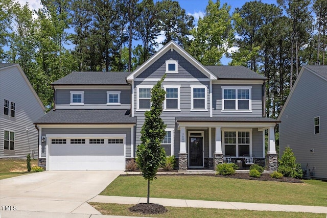 2009 Latham Oaks Ave, Wake Forest, NC 27587 - craftsman-style home with covered porch, a garage, concrete driveway, a front lawn, and stone siding