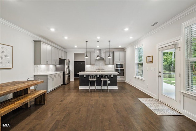 2009 Latham Oaks Ave, Wake Forest, NC 27587 - kitchen featuring stainless steel appliances, gray cabinetry, wall chimney exhaust hood, a kitchen bar, and recessed lighting