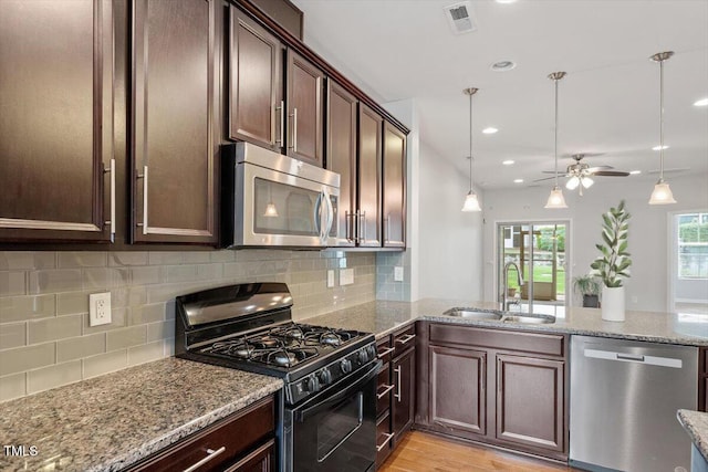 9327 Falkwood Rd, Raleigh, NC 27617 - kitchen featuring stainless steel appliances, a sink, dark brown cabinets, a ceiling fan, and light stone countertops