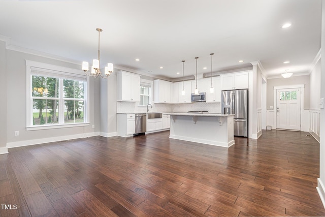 90 Starwood Dr, Garner, NC 27529 - kitchen with stainless steel appliances, ornamental molding, a chandelier, light countertops, and backsplash