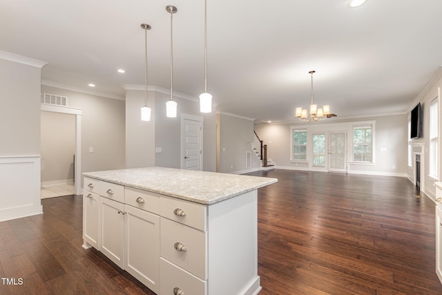 90 Starwood Dr, Garner, NC 27529 - kitchen with open floor plan, dark wood finished floors, crown molding, a center island, and decorative light fixtures
