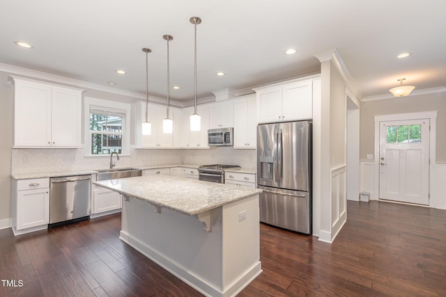 90 Starwood Dr, Garner, NC 27529 - kitchen featuring stainless steel appliances, crown molding, dark wood finished floors, a center island, and white cabinets