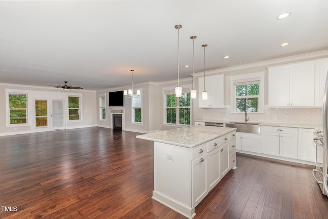 90 Starwood Dr, Garner, NC 27529 - kitchen featuring a sink, a fireplace, a kitchen island, tasteful backsplash, and ornamental molding
