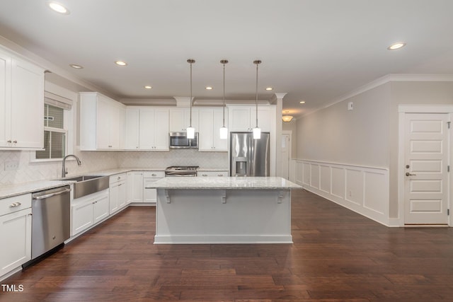 90 Starwood Dr, Garner, NC 27529 - kitchen featuring appliances with stainless steel finishes, crown molding, a center island, a sink, and white cabinets