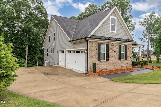 90 Starwood Dr, Garner, NC 27529 - view of side of property with concrete driveway, brick siding, a shingled roof, a garage, and a standing seam roof