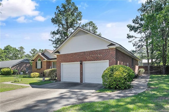 7578 Firethorn Dr, Fayetteville, NC 28311 - view of side of property with brick siding, an attached garage, and asphalt driveway