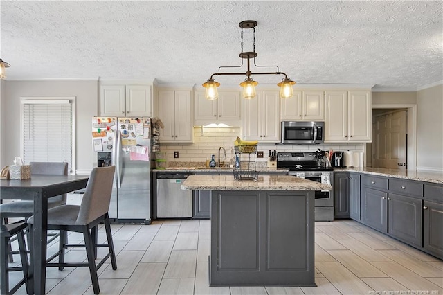 7578 Firethorn Dr, Fayetteville, NC 28311 - kitchen with stainless steel appliances, a sink, backsplash, a kitchen island, and gray cabinetry