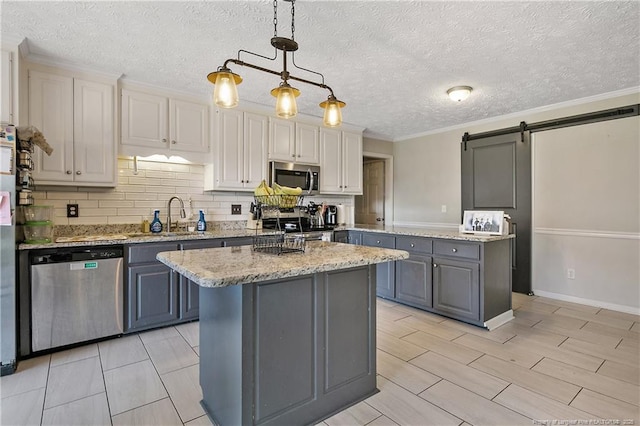 7578 Firethorn Dr, Fayetteville, NC 28311 - kitchen with stainless steel appliances, a kitchen island, gray cabinetry, backsplash, and pendant lighting