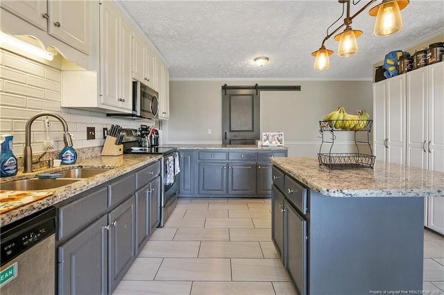 7578 Firethorn Dr, Fayetteville, NC 28311 - kitchen featuring stainless steel appliances, a sink, a kitchen island, a barn door, and light tile patterned floors