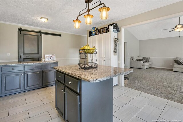 7578 Firethorn Dr, Fayetteville, NC 28311 - kitchen with a barn door, open floor plan, a center island, light stone counters, and light carpet