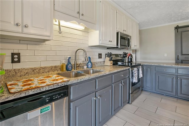 7578 Firethorn Dr, Fayetteville, NC 28311 - kitchen featuring appliances with stainless steel finishes, a sink, crown molding, white cabinets, and decorative backsplash