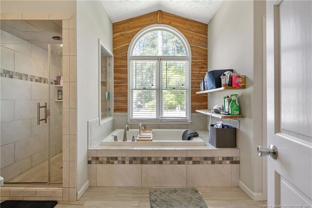 7578 Firethorn Dr, Fayetteville, NC 28311 - bathroom featuring a bath, a stall shower, and vaulted ceiling