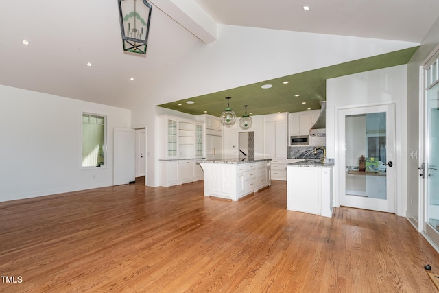 112 Lancaster Dr, Chapel Hill, NC 27517 - kitchen with high vaulted ceiling, a center island, white cabinets, stainless steel microwave, and beamed ceiling