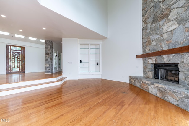 112 Lancaster Dr, Chapel Hill, NC 27517 - unfurnished living room featuring wood finished floors, a stone fireplace, built in shelves, baseboards, and recessed lighting