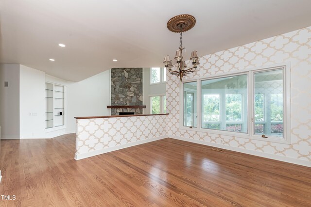 112 Lancaster Dr, Chapel Hill, NC 27517 - unfurnished room with wallpapered walls, a chandelier, baseboards, light wood-style flooring, and a fireplace