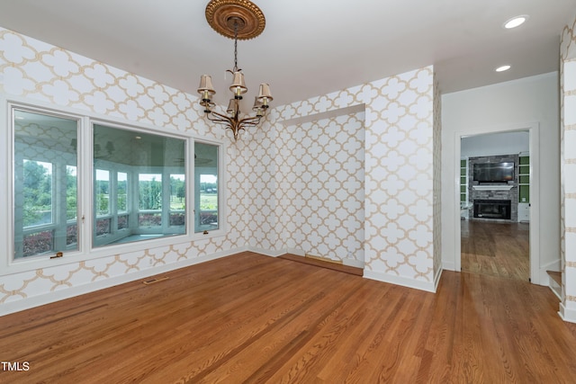 112 Lancaster Dr, Chapel Hill, NC 27517 - unfurnished dining area featuring wallpapered walls, a chandelier, light wood finished floors, baseboards, and a tiled fireplace