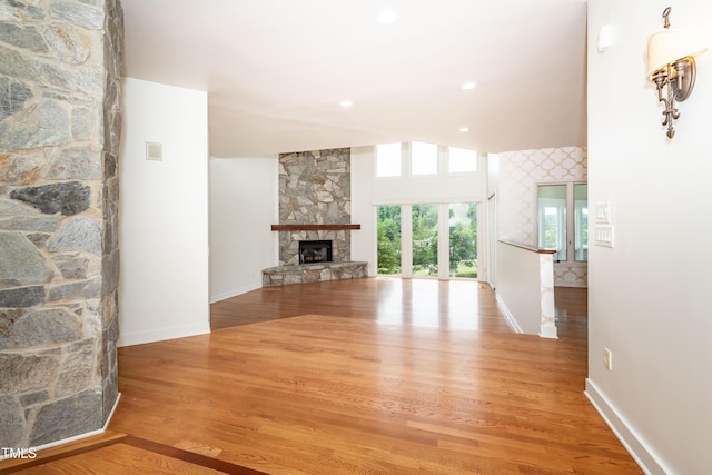 112 Lancaster Dr, Chapel Hill, NC 27517 - unfurnished living room featuring a stone fireplace, wood finished floors, and baseboards