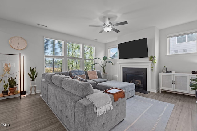 604 Craftsman Ridge Trl, Knightdale, NC 27545 - living room with a ceiling fan, a glass covered fireplace, wood finished floors, and baseboards