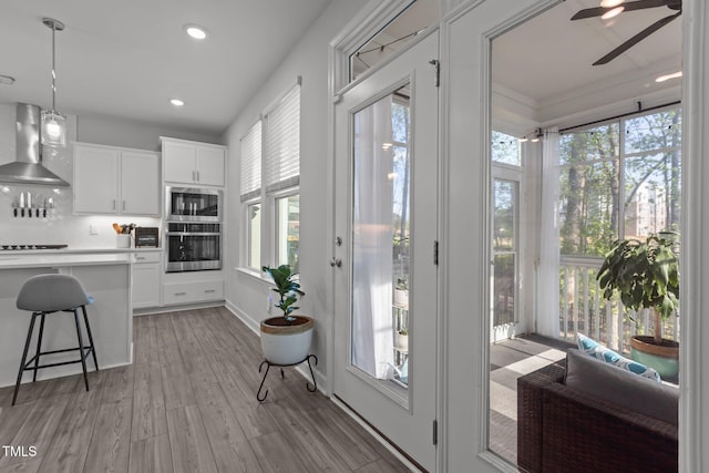 604 Craftsman Ridge Trl, Knightdale, NC 27545 - kitchen with wall chimney range hood, ceiling fan, plenty of natural light, a breakfast bar area, and recessed lighting