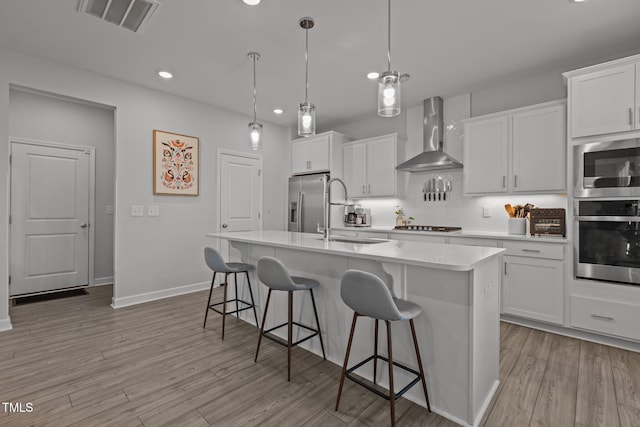 604 Craftsman Ridge Trl, Knightdale, NC 27545 - kitchen with wall chimney exhaust hood, a sink, appliances with stainless steel finishes, an island with sink, and decorative backsplash