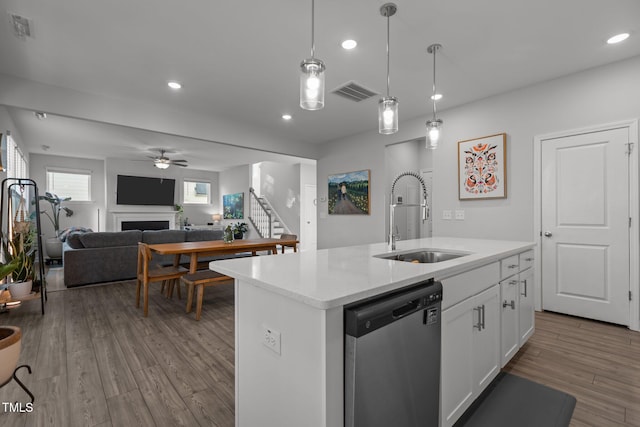 604 Craftsman Ridge Trl, Knightdale, NC 27545 - kitchen with dishwasher, a sink, a fireplace, recessed lighting, and white cabinetry